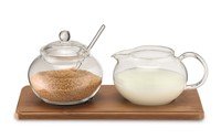Melkkannetje met suikerpot glas op bamboe-schotel